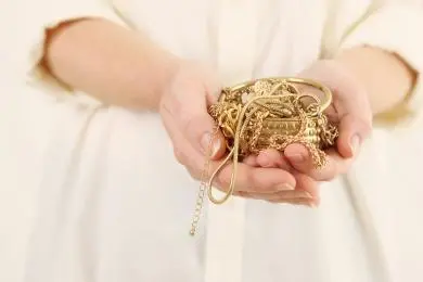 Cupped hands holding an assortment of scrap gold jewellery